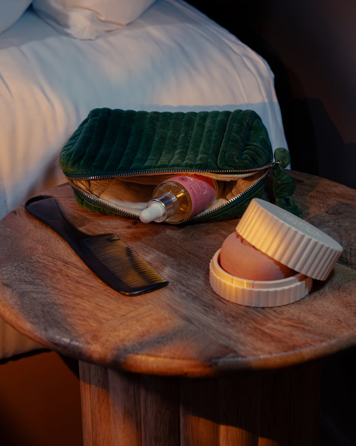 Galets de soin solides et écrin rechargeable posés sur une table en bois