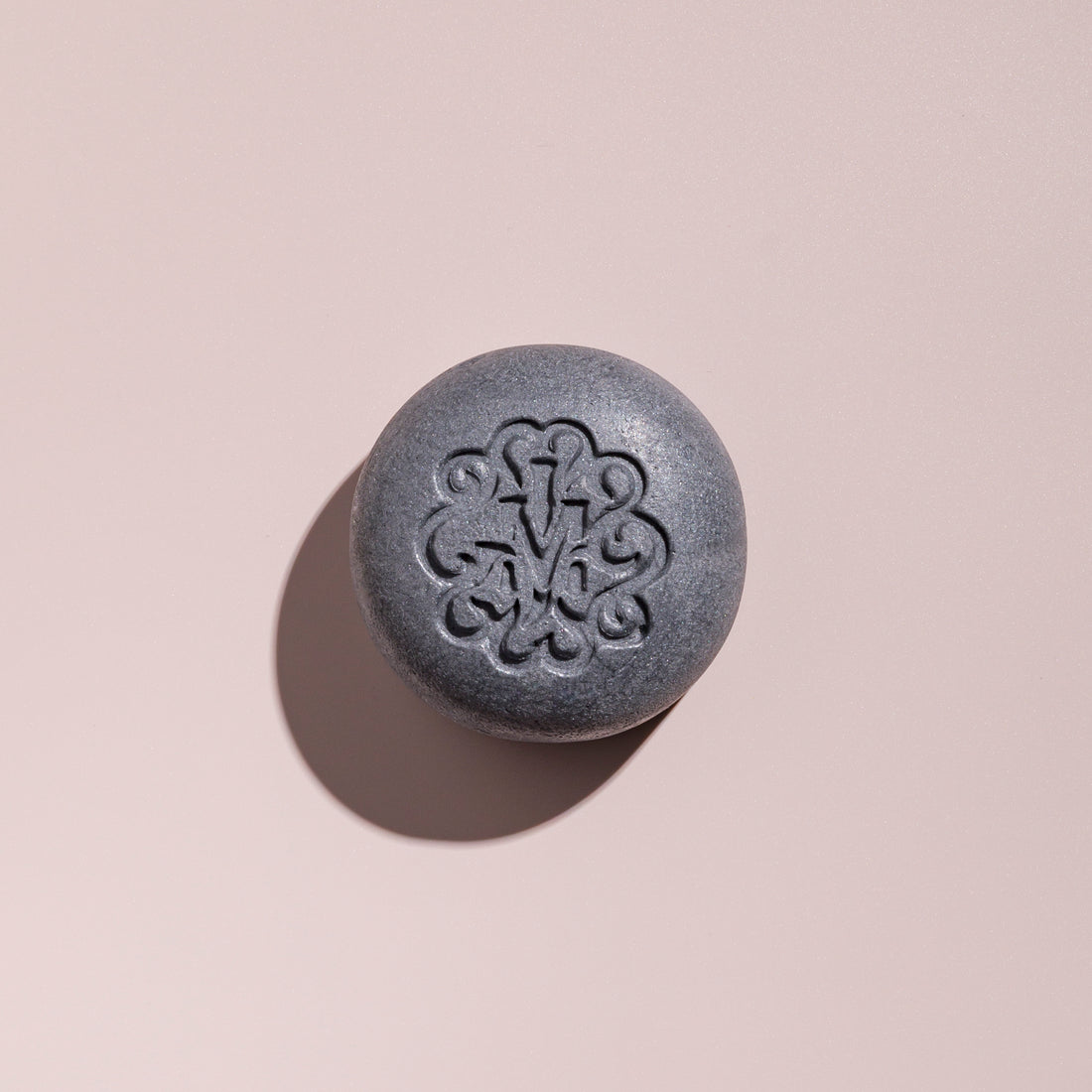 Shampoing solide fortifiant gris au charbon végétal, galet vu de dessus